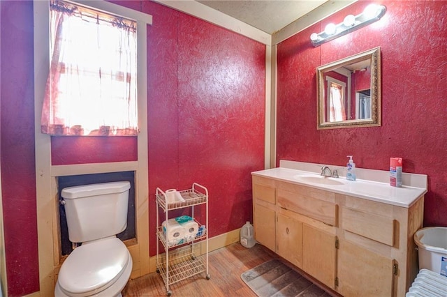 bathroom featuring plenty of natural light, hardwood / wood-style flooring, toilet, and vanity