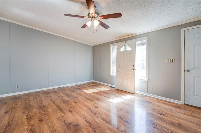 foyer with wood-type flooring, ceiling fan, a textured ceiling, and crown molding