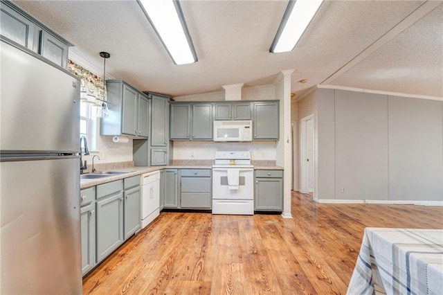 kitchen with white appliances, sink, crown molding, and light hardwood / wood-style flooring