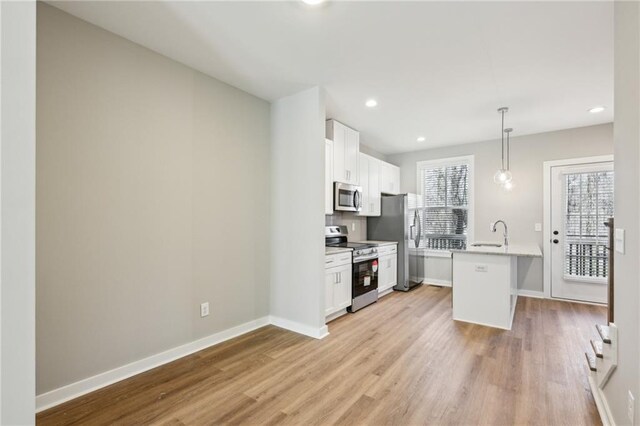 1095 Tucker Ave Unit 401, Atlanta, GA 30310 - kitchen featuring appliances with stainless steel finishes, a sink, a breakfast bar area, light wood-style flooring, and recessed lighting