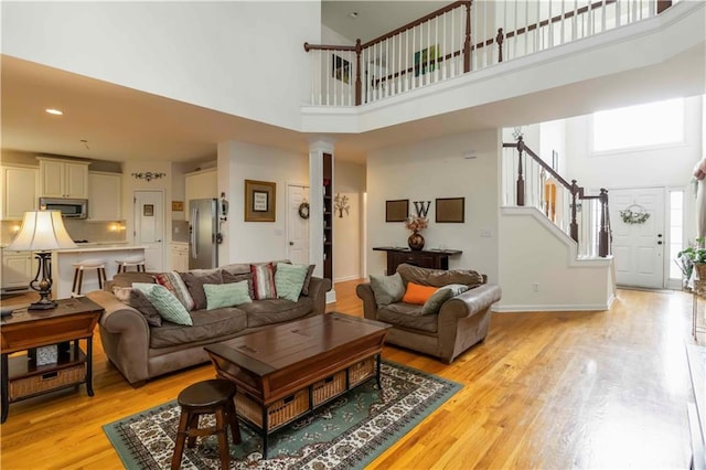 3780 Summit Gate Dr, Suwanee, GA 30024 - living area with a high ceiling, stairway, light wood finished floors, ornate columns, and recessed lighting