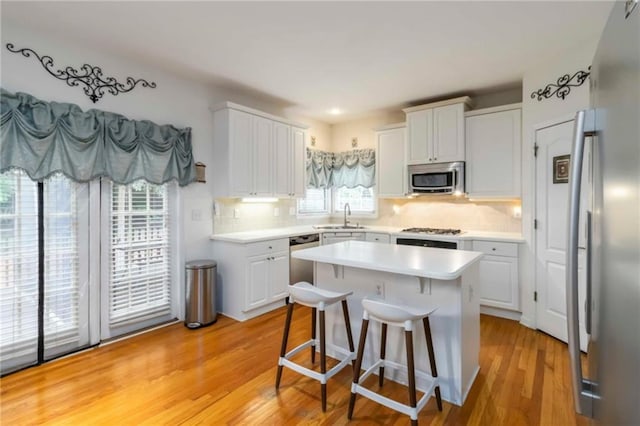 3780 Summit Gate Dr, Suwanee, GA 30024 - kitchen with stainless steel appliances, a sink, white cabinets, and light countertops