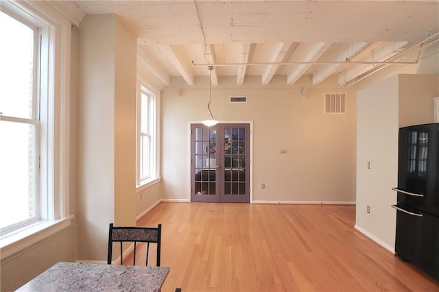 dining room with beamed ceiling, hardwood / wood-style floors, and french doors