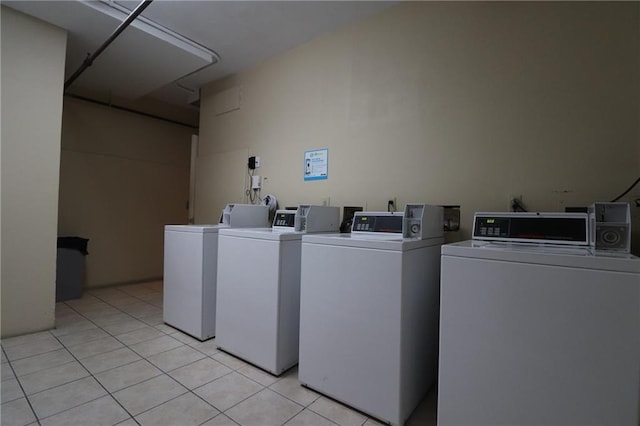 clothes washing area with light tile patterned floors and washer and clothes dryer