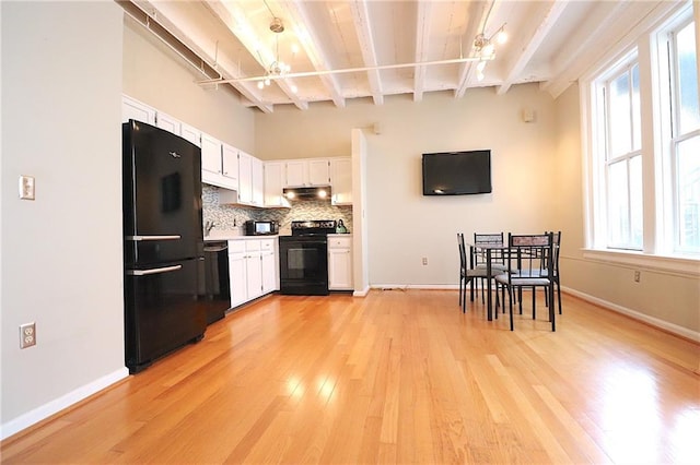 kitchen with a wealth of natural light, black appliances, white cabinets, decorative backsplash, and beamed ceiling