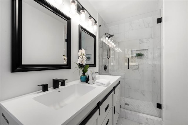 bathroom featuring double vanity, marble finish floor, a marble finish shower, and a sink