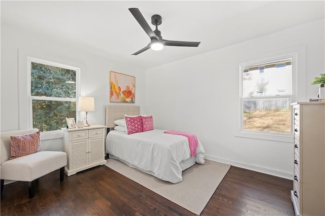 bedroom featuring multiple windows, dark wood-type flooring, and ceiling fan