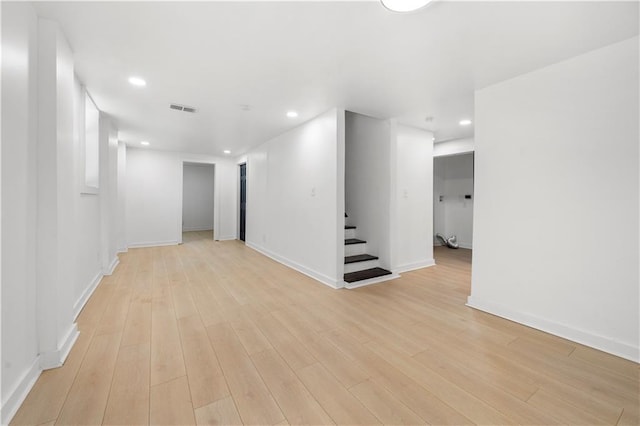 unfurnished room featuring recessed lighting, visible vents, baseboards, stairway, and light wood finished floors