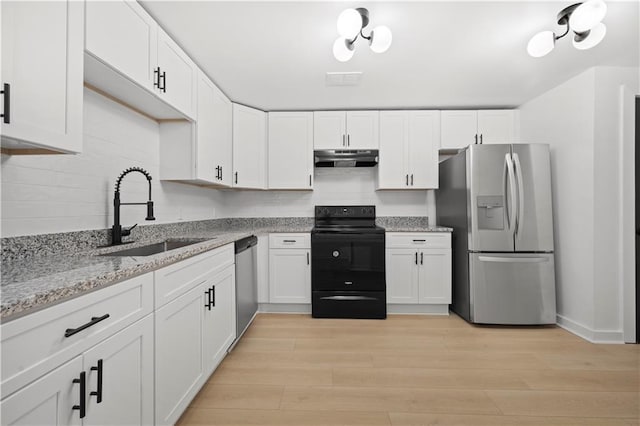 kitchen featuring appliances with stainless steel finishes, white cabinetry, sink, light stone counters, and light wood-type flooring