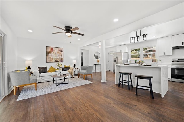 living area with dark wood-type flooring, recessed lighting, and a ceiling fan