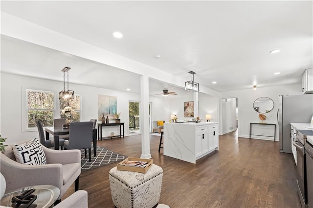 living area with dark wood finished floors, plenty of natural light, and recessed lighting