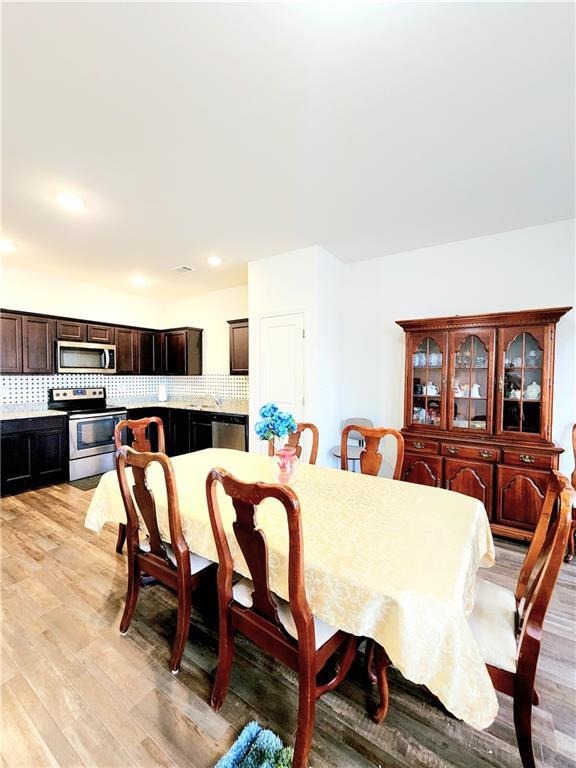 dining room with recessed lighting and light wood finished floors