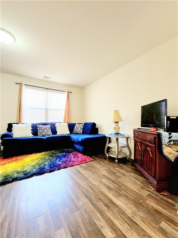 living room with wood finished floors and visible vents