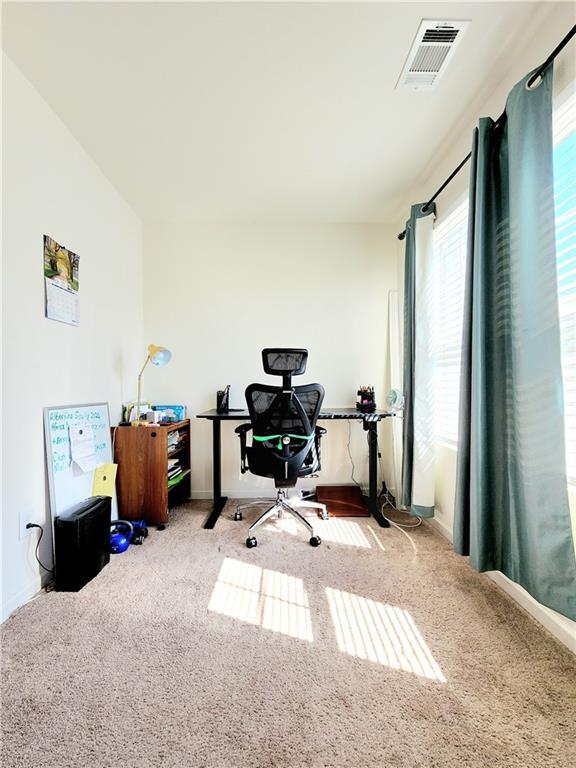 carpeted home office featuring visible vents