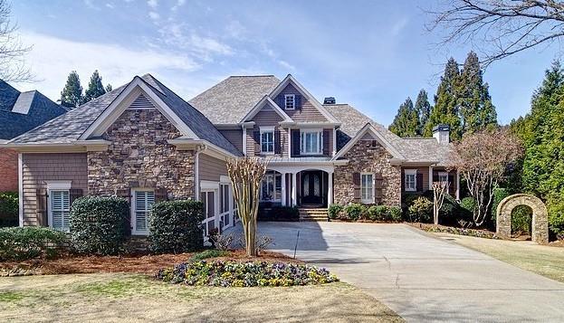 craftsman house with stone siding and concrete driveway