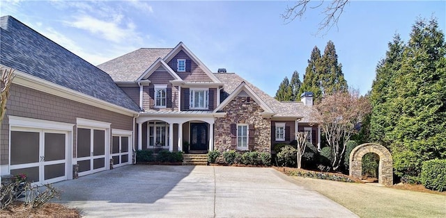 craftsman-style home with stone siding, concrete driveway, and a garage