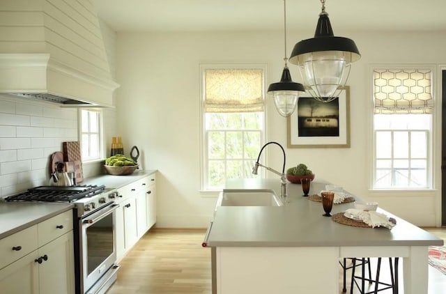 2067 Telfair Cir Unit A & B, Atlanta, GA 30324 - kitchen featuring stainless steel range with gas cooktop, a sink, custom exhaust hood, decorative backsplash, and light wood-type flooring