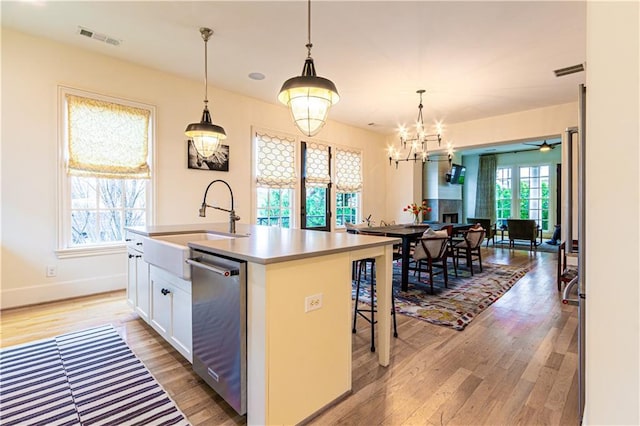 2067 Telfair Cir Unit A & B, Atlanta, GA 30324 - kitchen featuring dishwasher, light wood-style flooring, a sink, a kitchen island with sink, and white cabinetry