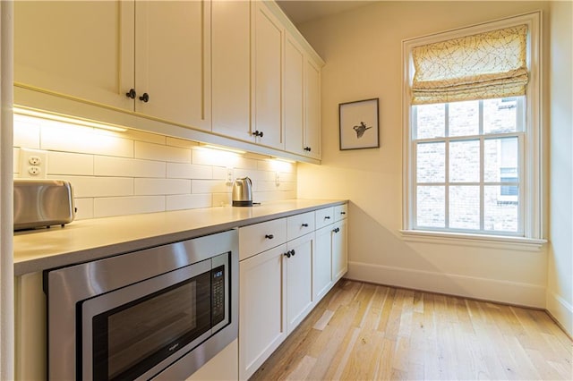 2067 Telfair Cir Unit A & B, Atlanta, GA 30324 - kitchen featuring stainless steel microwave, baseboards, light wood-type flooring, backsplash, and light countertops