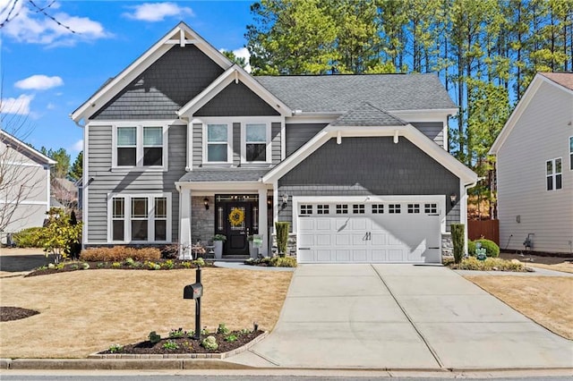 craftsman house featuring driveway, stone siding, and an attached garage