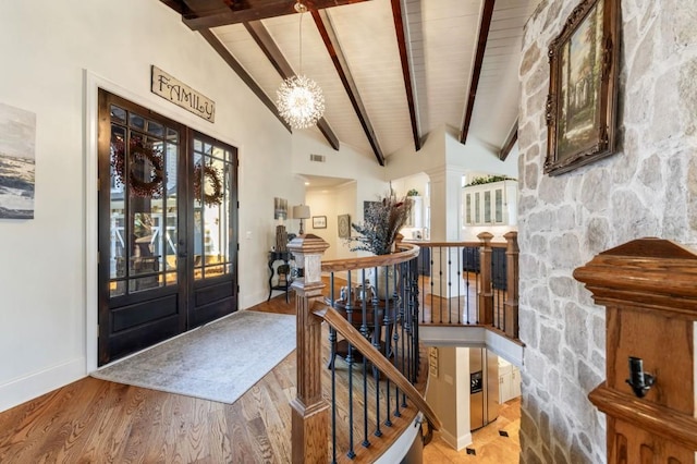 foyer featuring high vaulted ceiling, beamed ceiling, wood-type flooring, an inviting chandelier, and french doors