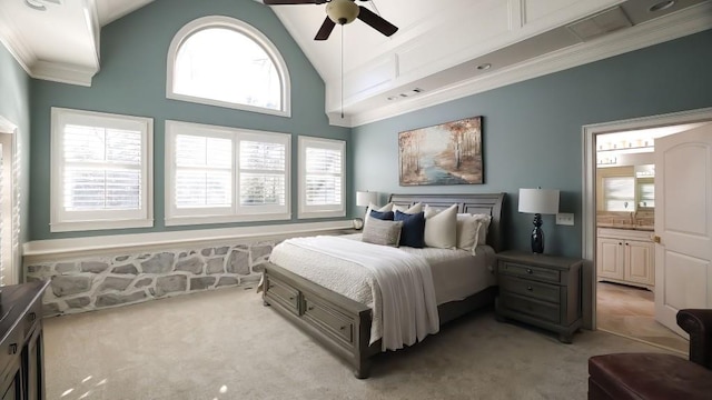 bedroom featuring ceiling fan, ensuite bathroom, high vaulted ceiling, and light colored carpet