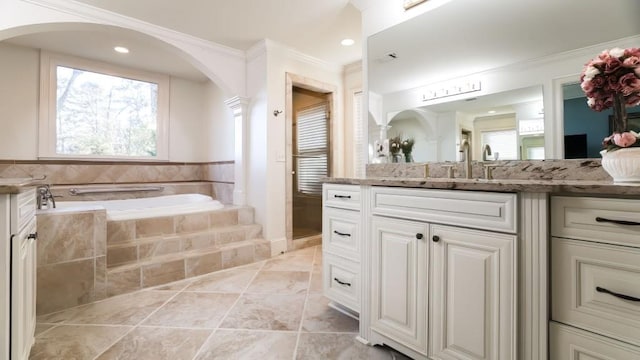 bathroom with tiled tub, vanity, tile patterned flooring, and crown molding