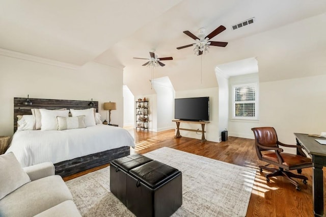 bedroom featuring vaulted ceiling, ceiling fan, ornamental molding, and hardwood / wood-style floors