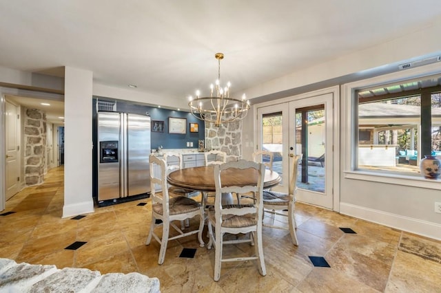 dining space with french doors and a notable chandelier