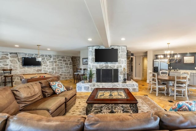 living room with a stone fireplace, a chandelier, and beam ceiling