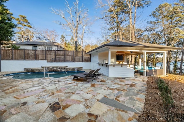 view of swimming pool with an outdoor living space, a patio, exterior bar, and pool water feature