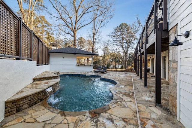 view of swimming pool with pool water feature and a patio area