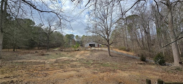 view of yard featuring a wooded view and an outdoor structure