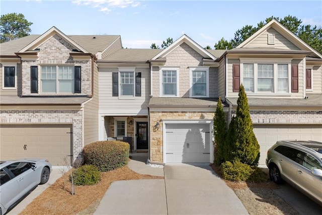 multi unit property with stone siding, driveway, and a garage