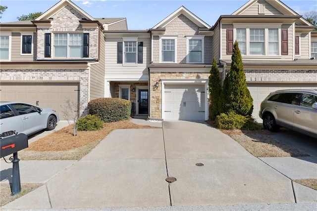 view of property with stone siding, brick siding, concrete driveway, and an attached garage