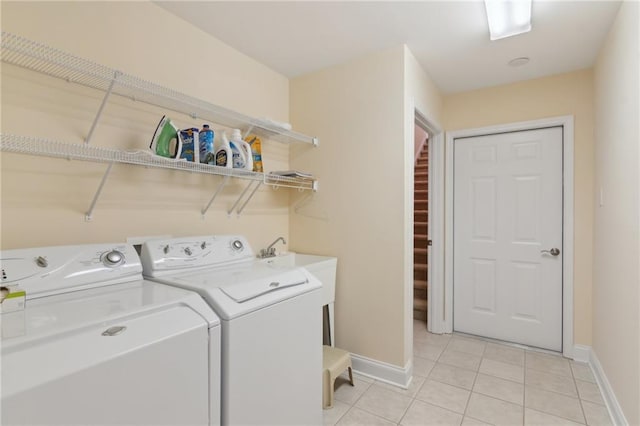 laundry area with washing machine and dryer and light tile patterned floors