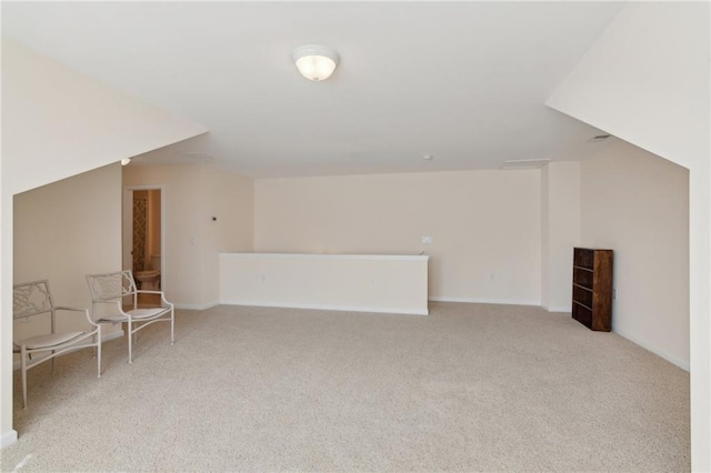 additional living space featuring light carpet and vaulted ceiling