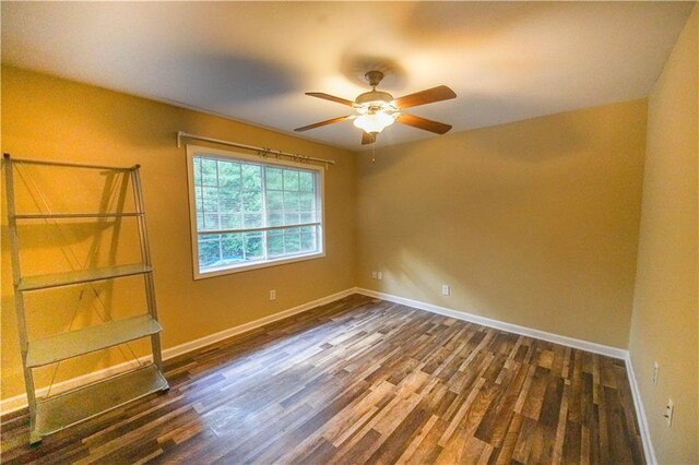 unfurnished room with ceiling fan and dark hardwood / wood-style flooring