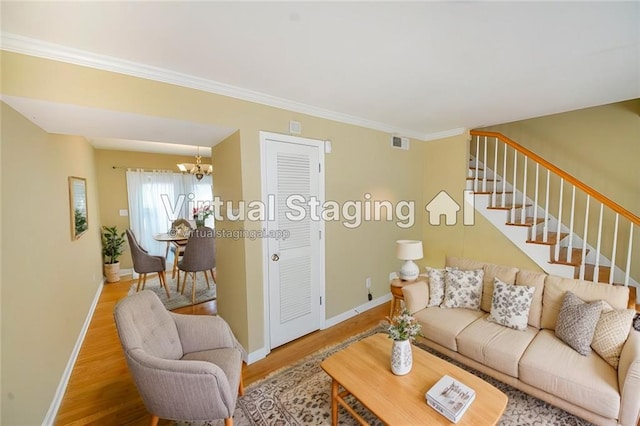 living room with hardwood / wood-style floors, a chandelier, and ornamental molding