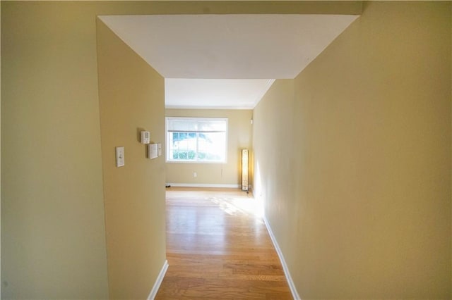 corridor with light hardwood / wood-style floors