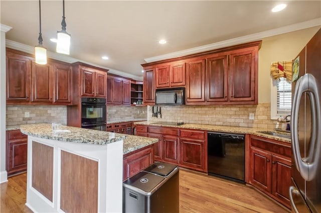 kitchen with light hardwood / wood-style floors, a kitchen island, pendant lighting, black appliances, and ornamental molding