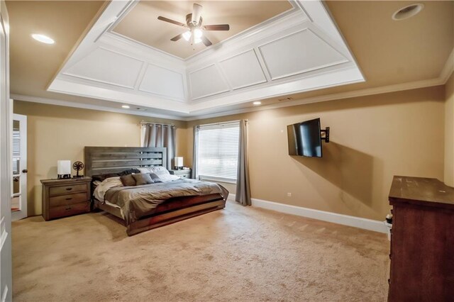 carpeted bedroom with a raised ceiling, crown molding, and ceiling fan