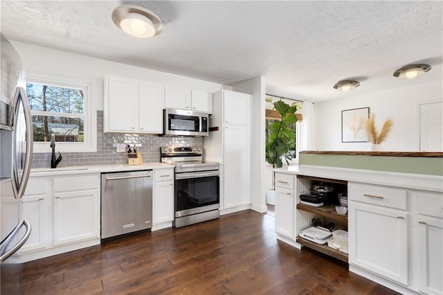 kitchen featuring dark wood-style floors, light countertops, appliances with stainless steel finishes, and backsplash