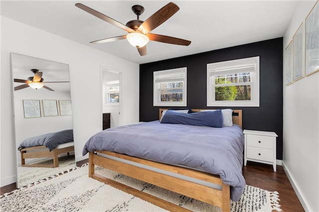 bedroom featuring wood finished floors, a ceiling fan, and baseboards