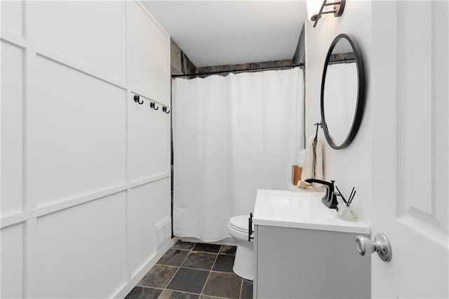 bathroom with visible vents, a shower with shower curtain, vanity, and toilet