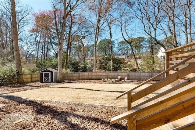 view of yard with an outbuilding, a fenced backyard, and a storage shed