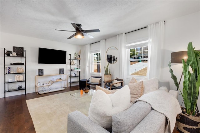 living room featuring dark wood-style floors, a textured ceiling, and a ceiling fan