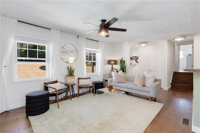 living room with visible vents, baseboards, and hardwood / wood-style flooring