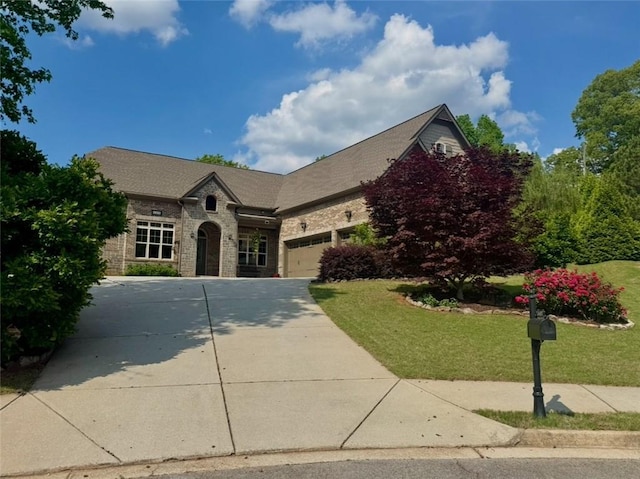 view of front facade with concrete driveway, an attached garage, stone siding, and a front lawn