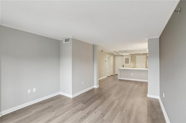 unfurnished living room with crown molding and light wood-type flooring